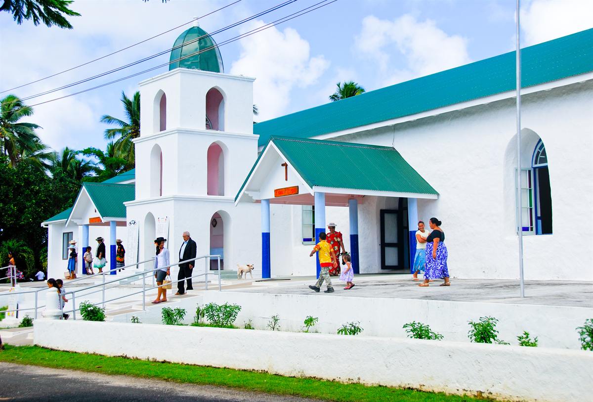 People arriving at the white CICC church on Enuamanu (Atiu)